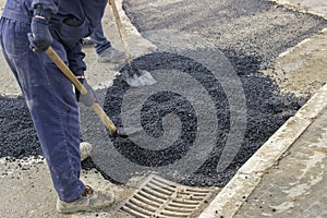 Asphalt workers with shovels patching asphalt 2