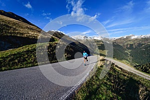 Asphalted mountain road with lonely runner in training