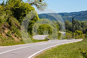 Asphalted road with curves and unevenness in the countryside