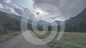 Asphalted road leading up to the mountains in forest - vintage r