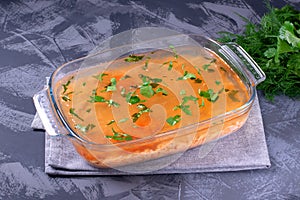 Aspic with red fish topped with herbs in the glass dish
