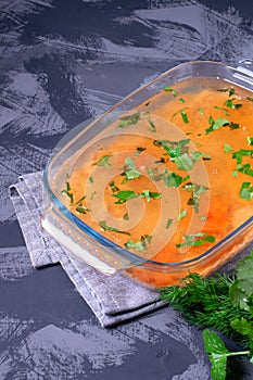 Aspic with red fish topped with herbs in the glass dish