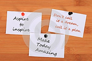 `Aspire to inspire`. `Don`t call it a dream, call it a plan.` `Make Today Amazing`. Note pin on the bulletin board. photo