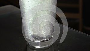 Aspirin or effervescent pill dropping into a glass of water