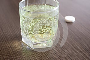 Aspirin or effervescent pill tablet sparkling bubbles in glass of water