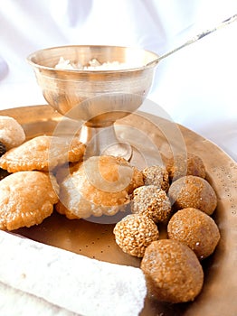 Assamese traditional food items like pitha, laddu, doi sira with assamese gamosa background