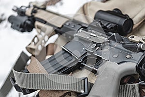 An assault rifle lies on a military briefcase