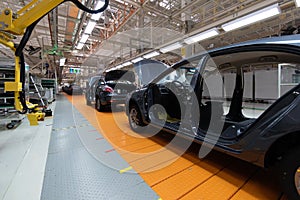 Assembled car is on the Assembly line. Robotic equipment makes the Assembly of the car. Modern car Assembly at the photo