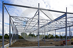 Assembled steel framework of new modern industrial building with foundation concrete panel border