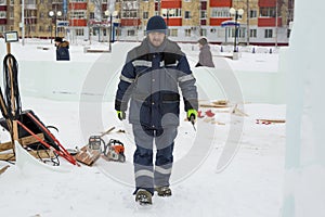 Assembler in overalls on the territory of the ice town