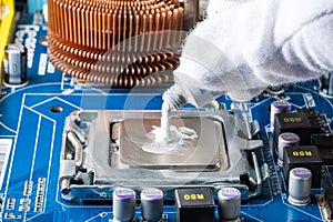 Assembling a computer in white gloves, applying thermal paste to the processor