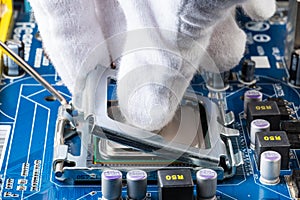 Assembling a computer in white gloves, installing a processor in its socket