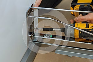 Assembling furniture white large trash can screws using a screwdriver