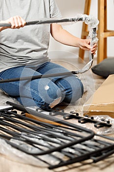 Assembling new furniture from a box in a home interior, vertically