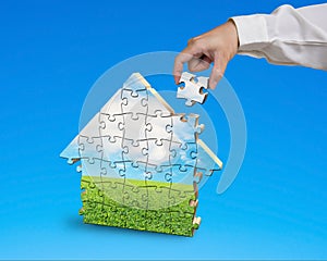 Assembling puzzles in house shape in blue background