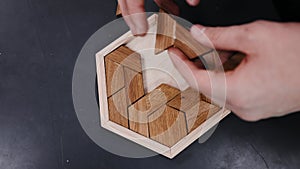 Assembling a tabletop wooden puzzle in slow motion.