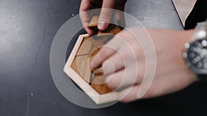 Assembling a tabletop wooden puzzle in slow motion.