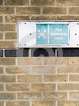 Assembly point sign on brick wall