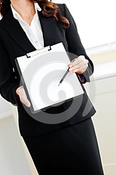Assertive businesswoman taking notes on clipboard
