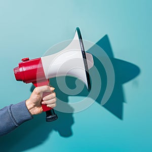 Assertive communication hand holds megaphone casting sharp shadow