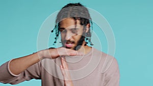 Assertive man asking for timeout, doing hand gestures, studio background