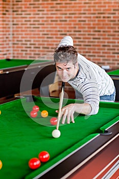 Assertive young man playing snooker