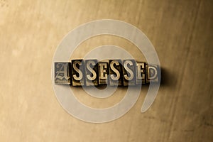 ASSESSED - close-up of grungy vintage typeset word on metal backdrop photo