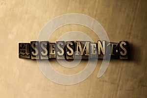 ASSESSMENTS - close-up of grungy vintage typeset word on metal backdrop