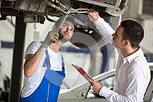 Assessor and repair man examine car