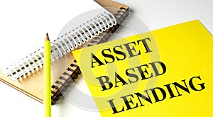 ASSET BASED LENDING text on yellow paper with notebooks