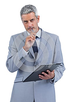 Assiduous businessman holding clipboard and taking notes