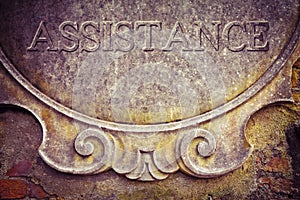 Assistance text written on old stucco wall - concept image