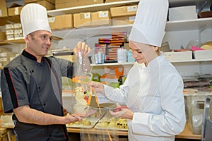 Assistant and chef discussing menu in kitchen