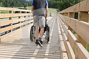 Assistant and disabled young man on a wheelchair