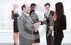 Assistant meets a businessman with a handshake. meetings and partnership