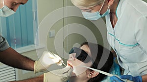 Assistant oversees work treating of dentist in dental clinic office