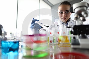 Assistant pouring liquid into flask