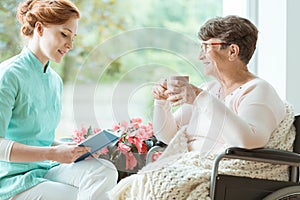 Assistant reading book to elder