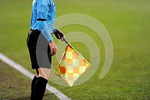 Assistant referee signalling with the flag