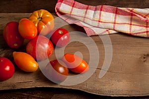 Assort of different shape and color tomatoes on wooden background