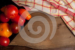 Assort of different shape and color tomatoes on wooden background