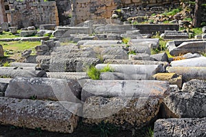 Assorted ancient archeological pillars lined up on the ground at Corinth Greece - selective focus