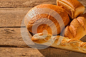 Assorted artisan bread on wooden background.