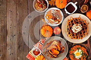 Assorted autumn breakfast or brunch items. Side border against a dark wood background with copy space.