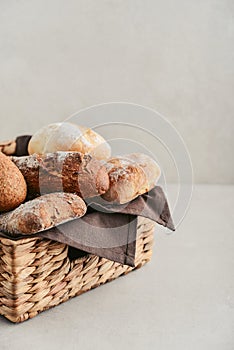 Assorted bakery products including loafs of bread, baguette and rolls in basket