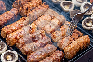 Assorted barbecue of meat rolls or mici and champignon mushrooms