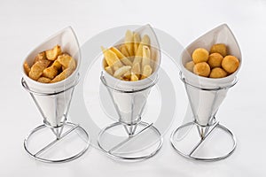 Assorted beer snacks like potato wedges, french fries and cheese balls isolated on white background