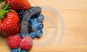 Assorted Berries on wood background