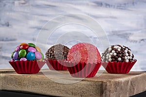 Assorted brigadeiros on wooden board with multicolored background photo