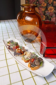 assorted bruschetta on a white plate on the table